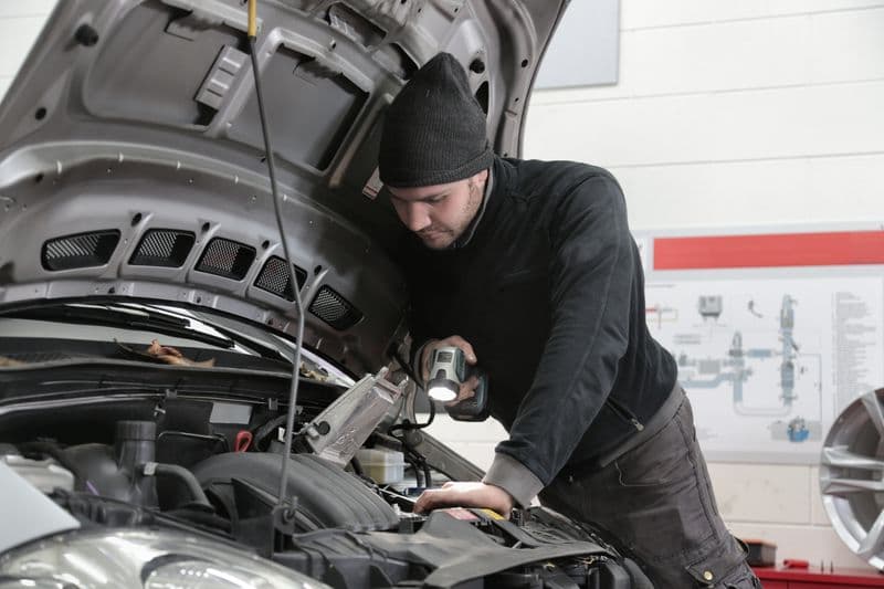 Technician checking vehicle air conditioning system